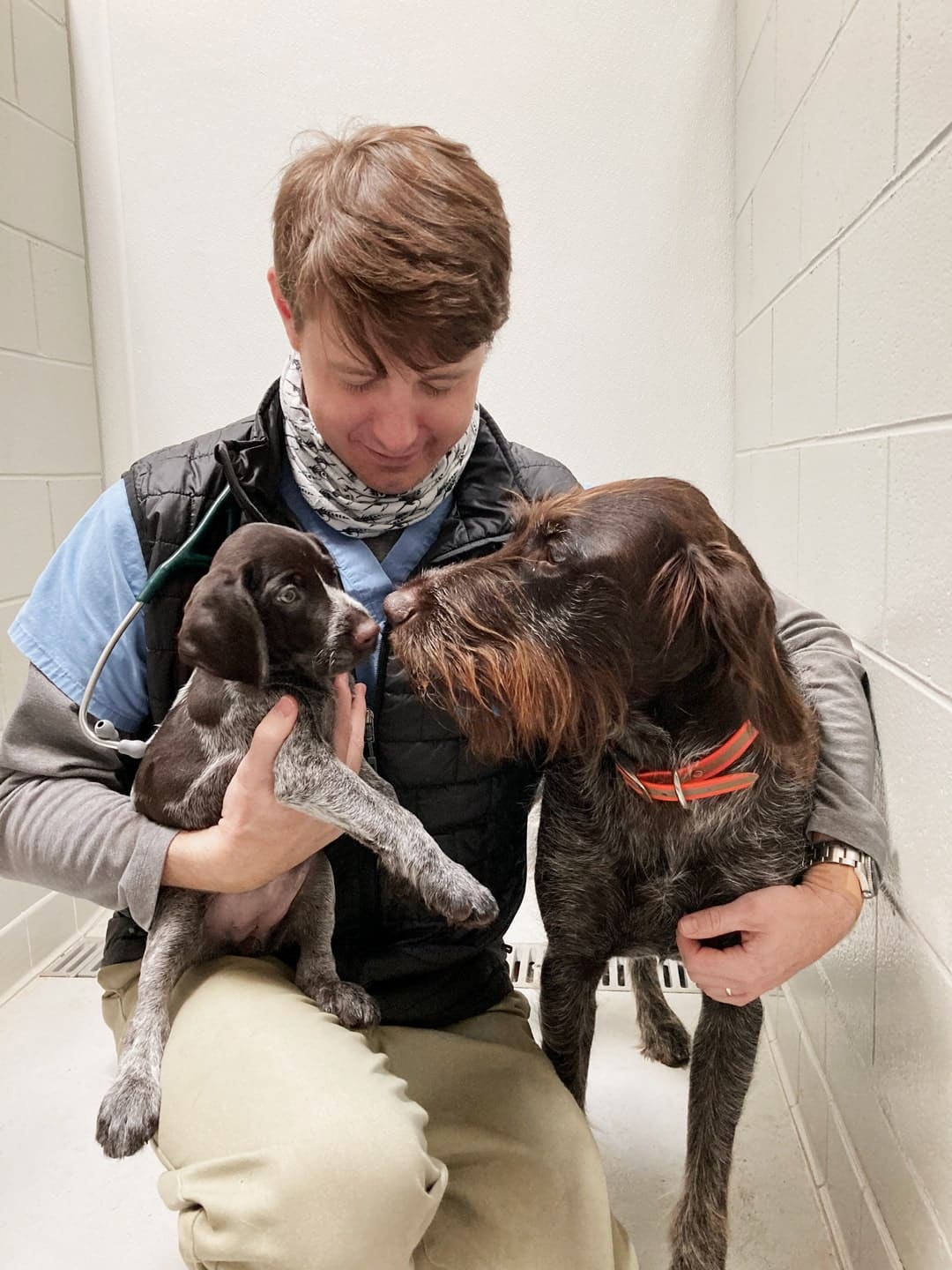 dr jackson walker holding a dog and a puppy at walker canine care